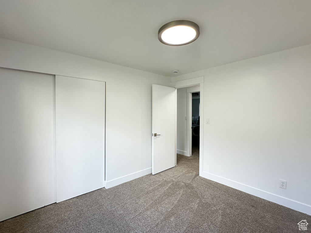 Unfurnished bedroom with light colored carpet and a closet