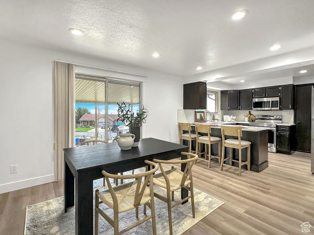 Dining space featuring sink, plenty of natural light, and light hardwood / wood-style flooring