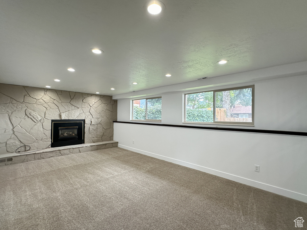 Unfurnished living room with carpet and a fireplace