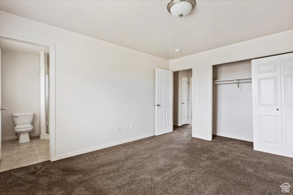 Unfurnished bedroom featuring carpet, a closet, and ensuite bathroom