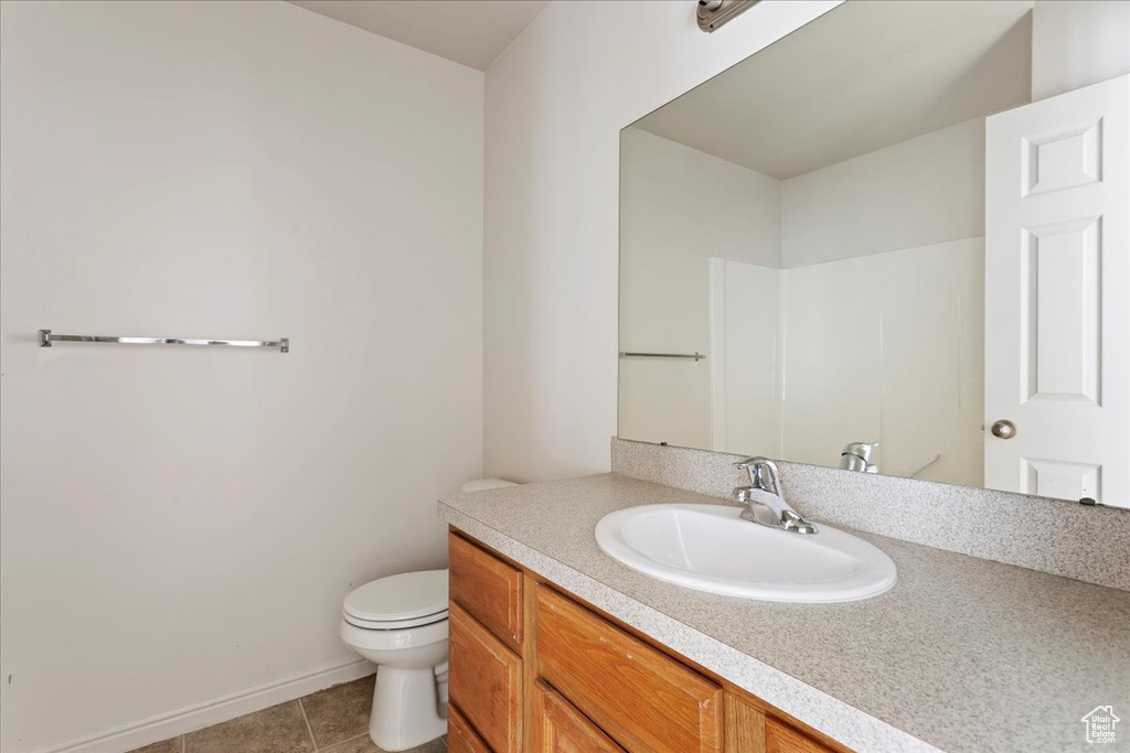 Bathroom featuring tile patterned floors, toilet, and vanity