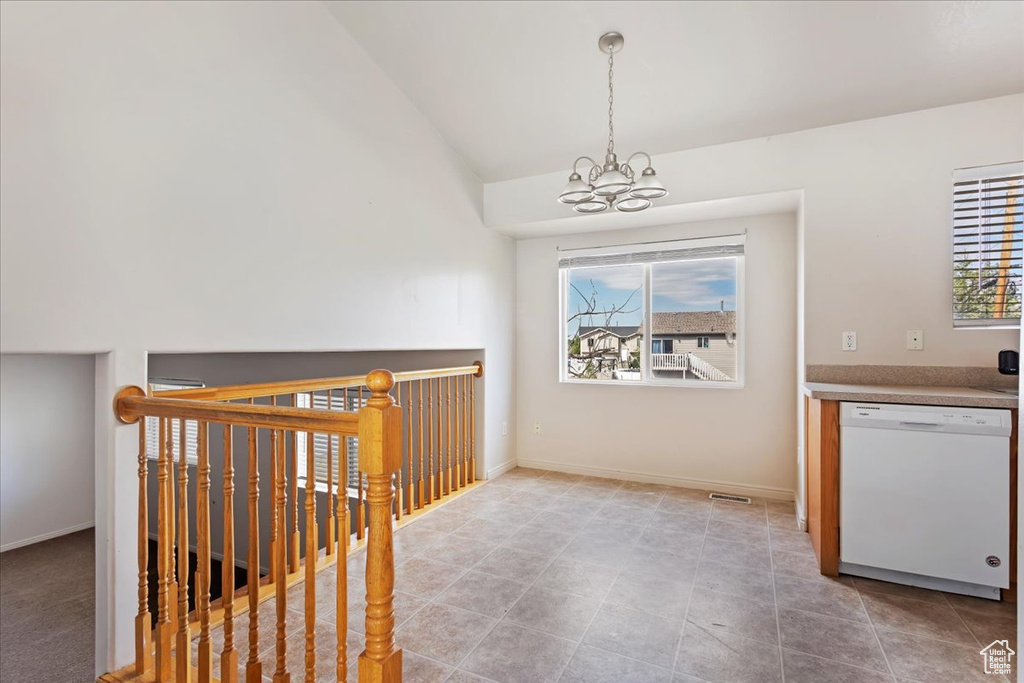 Interior space featuring a notable chandelier, vaulted ceiling, and light tile patterned floors