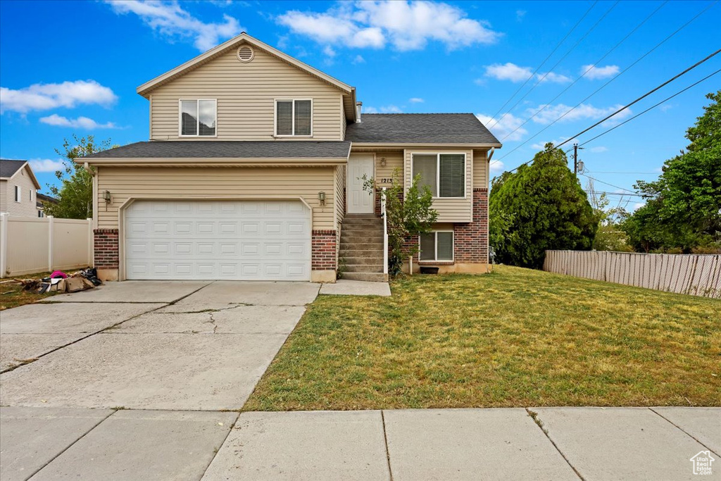 View of front of property with a front yard and a garage