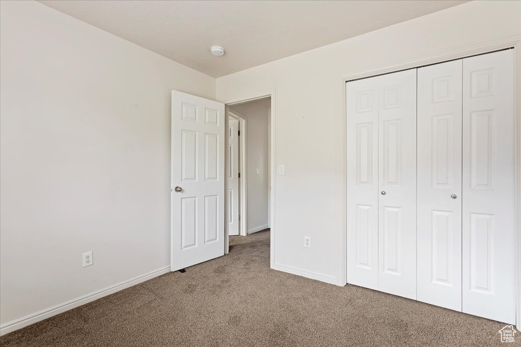 Unfurnished bedroom featuring carpet floors and a closet