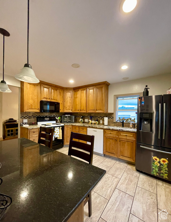 Kitchen featuring backsplash, pendant lighting, light tile patterned floors, sink, and white appliances