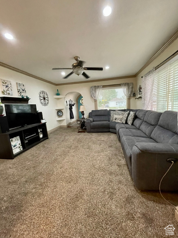 Carpeted living room with ceiling fan and ornamental molding