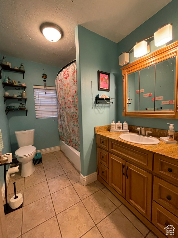 Full bathroom featuring toilet, vanity, tile patterned floors, a textured ceiling, and shower / bathtub combination with curtain