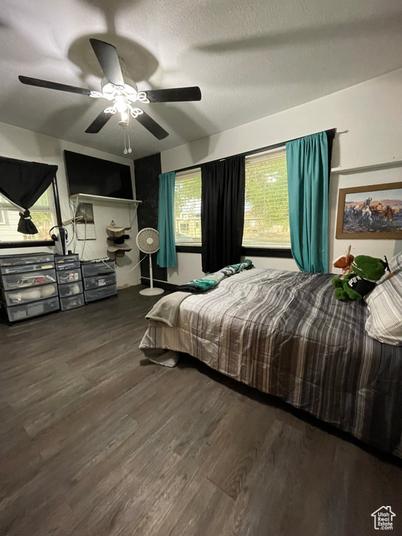 Bedroom featuring ceiling fan, wood-type flooring, and a textured ceiling