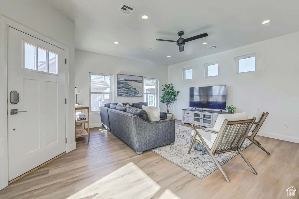 Living room featuring ceiling fan, plenty of natural light, and light hardwood / wood-style flooring
