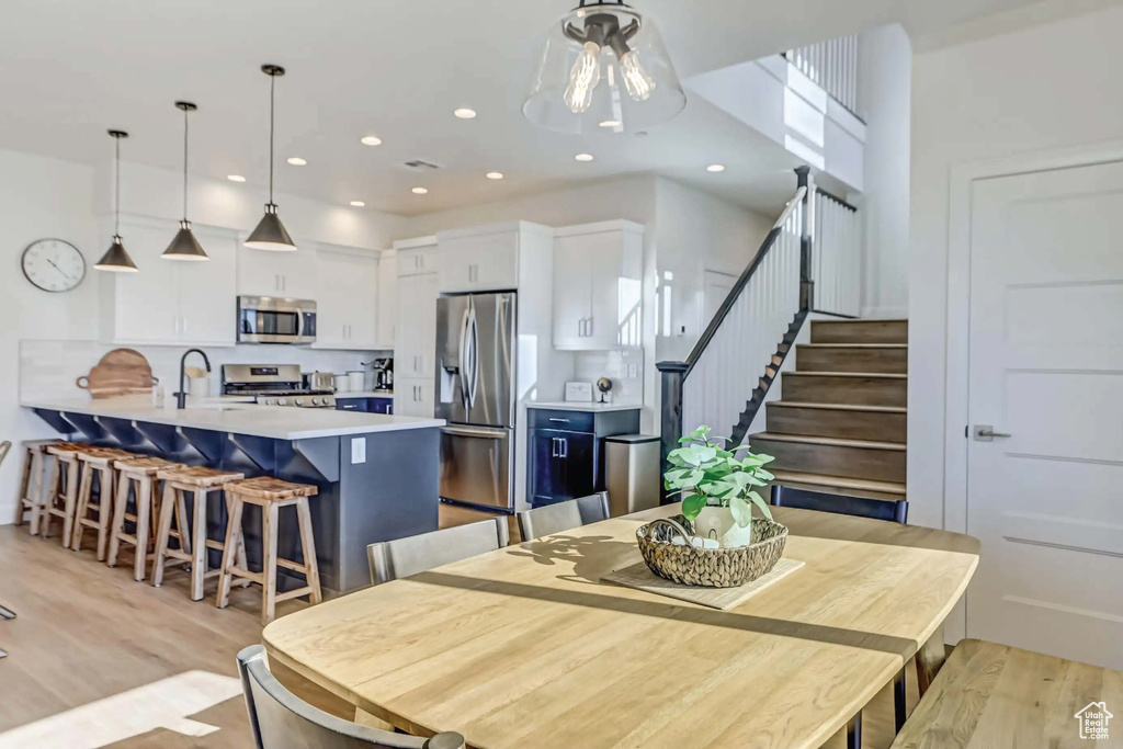 Dining space with light hardwood / wood-style floors and sink