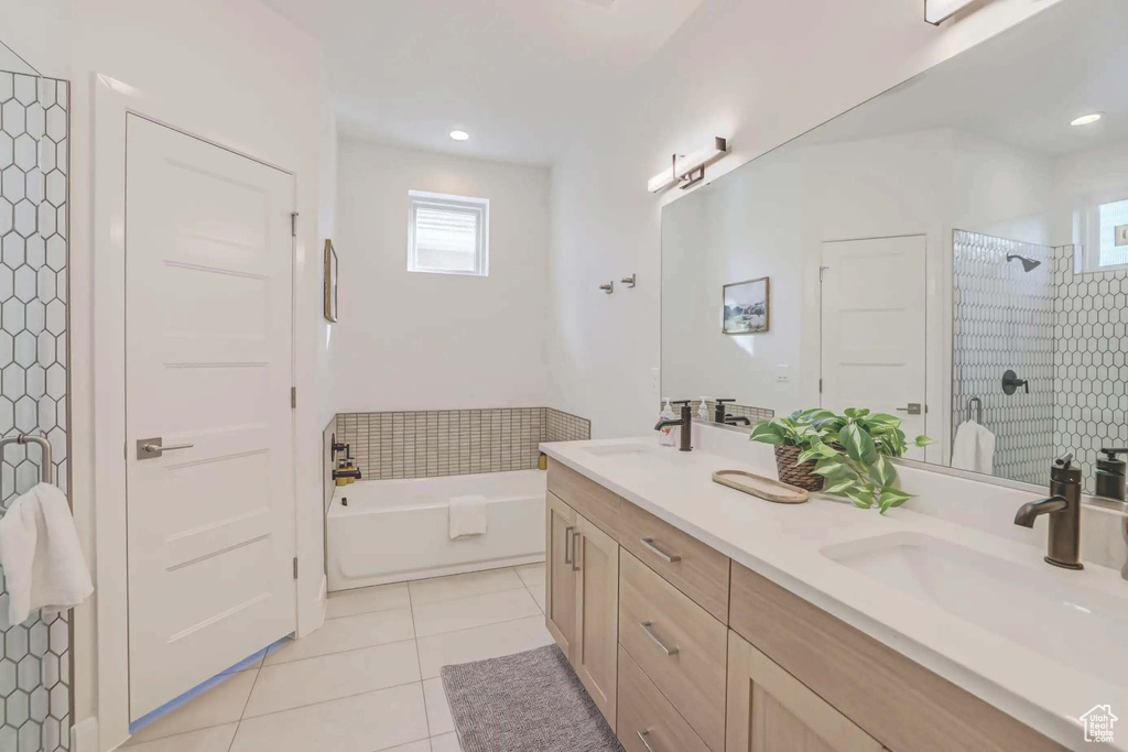 Bathroom featuring plus walk in shower, vanity, and tile patterned floors