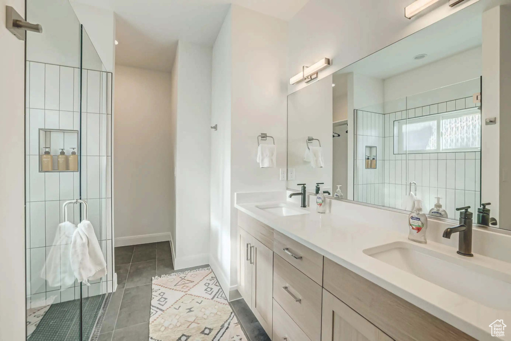 Bathroom with tile patterned flooring, vanity, and walk in shower