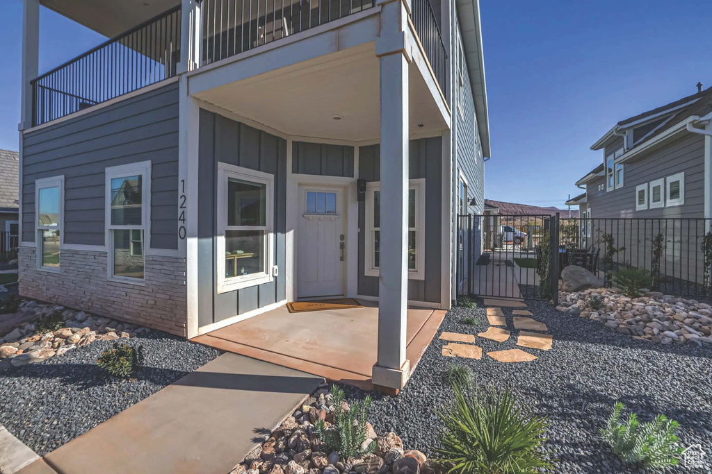 Entrance to property featuring a balcony and a patio