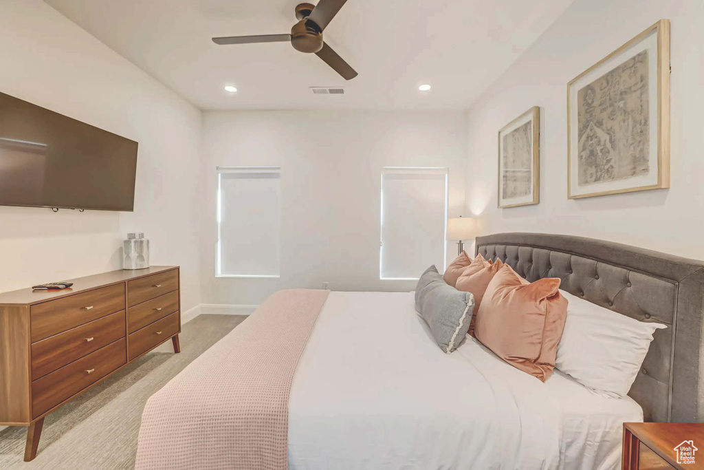 Bedroom with ceiling fan and light carpet