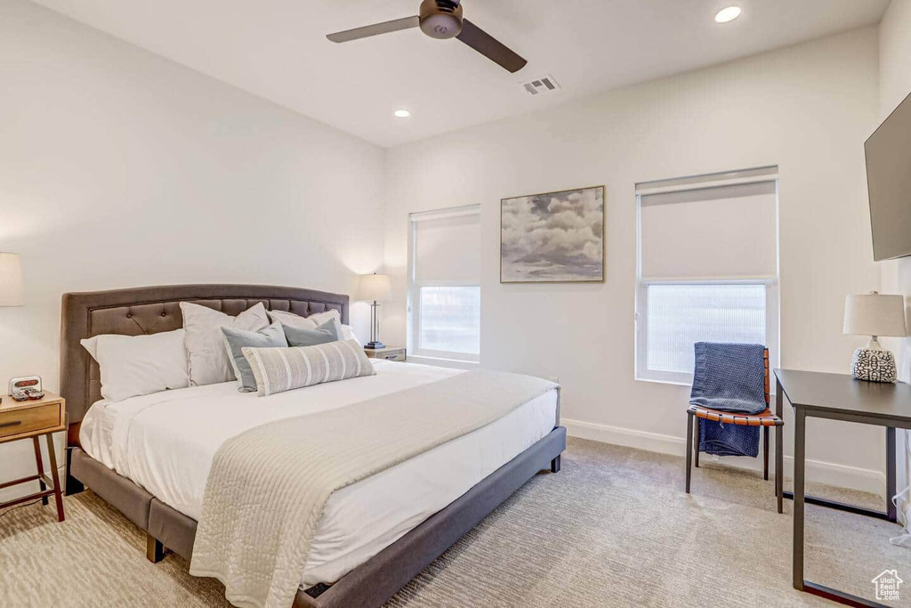 Bedroom featuring ceiling fan, light colored carpet, and multiple windows