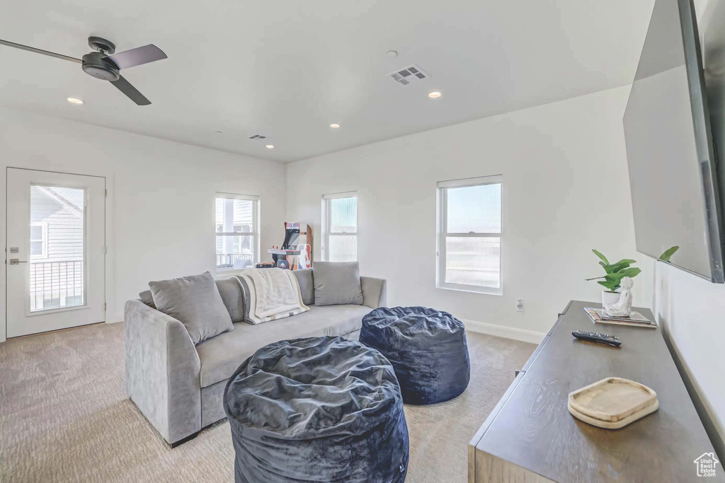 Carpeted living room with ceiling fan