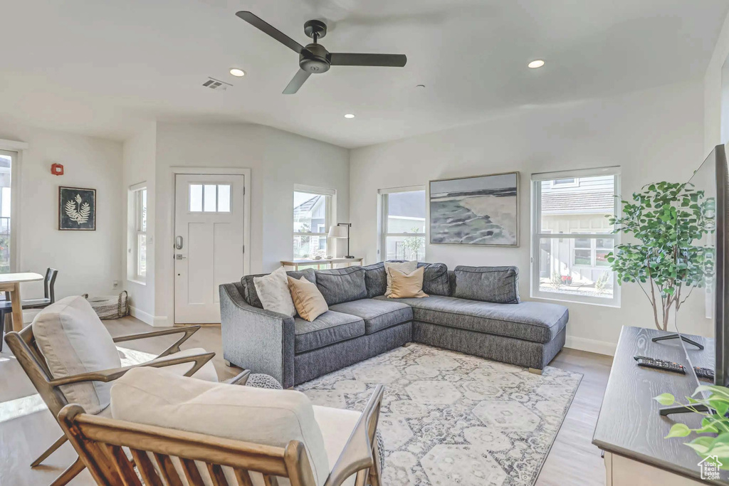 Living room with ceiling fan, light hardwood / wood-style flooring, and a healthy amount of sunlight
