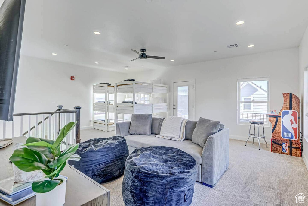 Living room with ceiling fan and light carpet