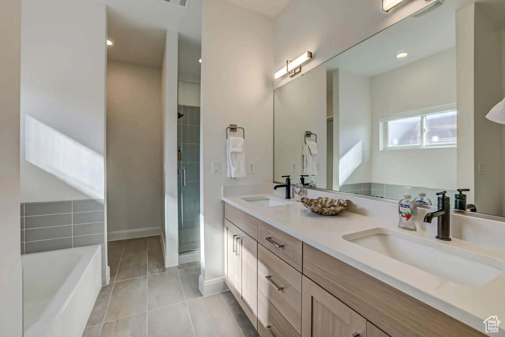 Bathroom with tile patterned floors, independent shower and bath, and vanity