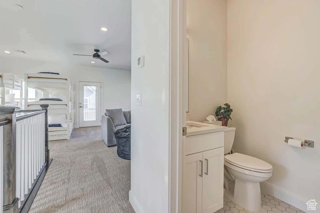 Bathroom with ceiling fan, toilet, tile patterned flooring, and vanity