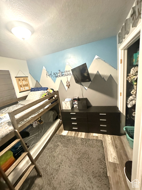 Miscellaneous room with a textured ceiling and wood-type flooring