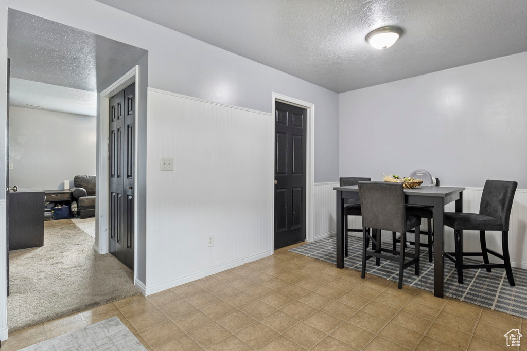 Dining room featuring a textured ceiling and light colored carpet