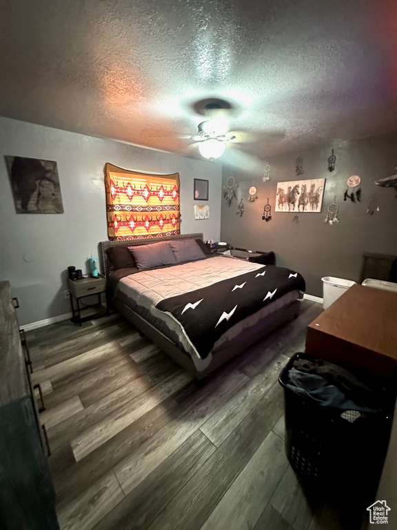 Bedroom with a textured ceiling, ceiling fan, and hardwood / wood-style flooring