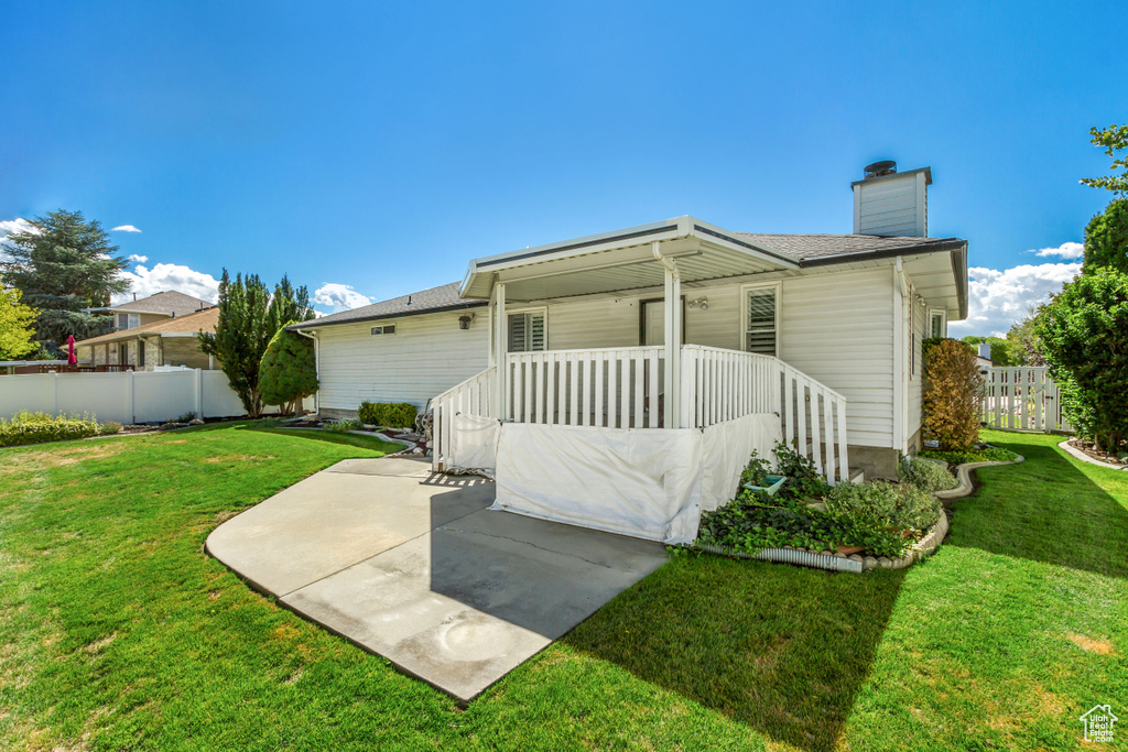 Rear view of property with a patio and a lawn