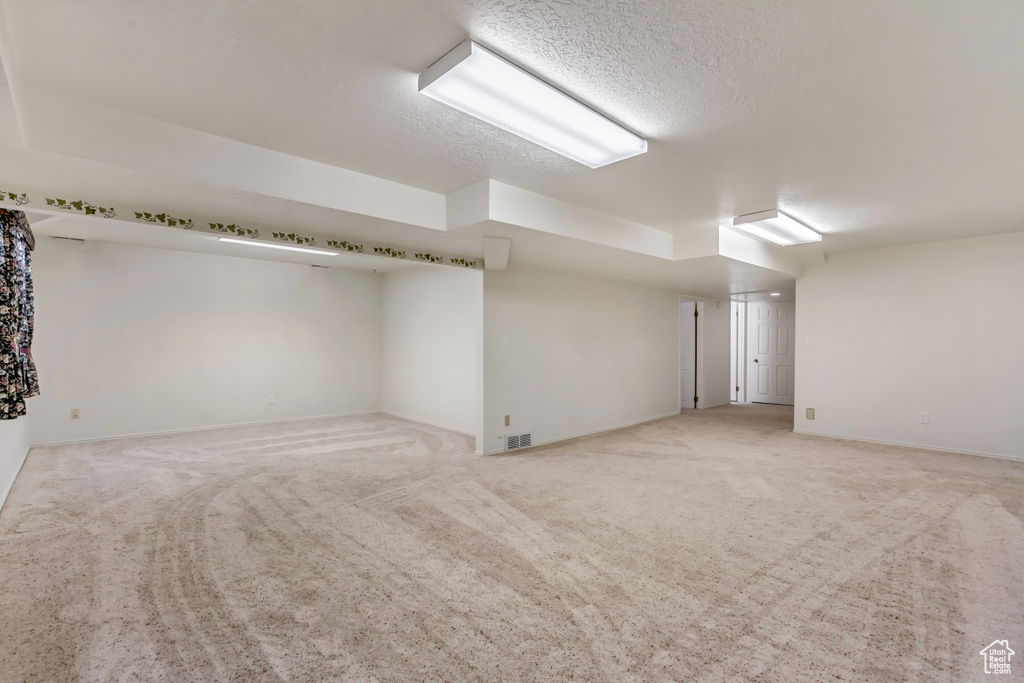 Interior space with a textured ceiling and light carpet