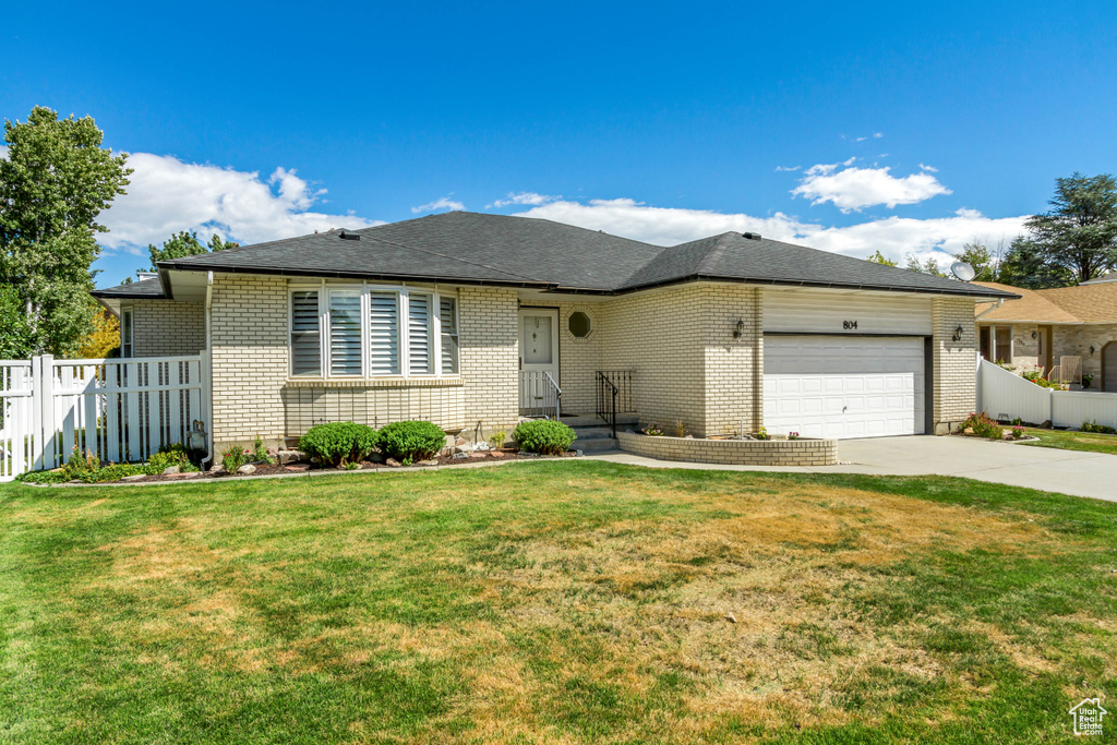 View of front of home featuring a front yard and a garage