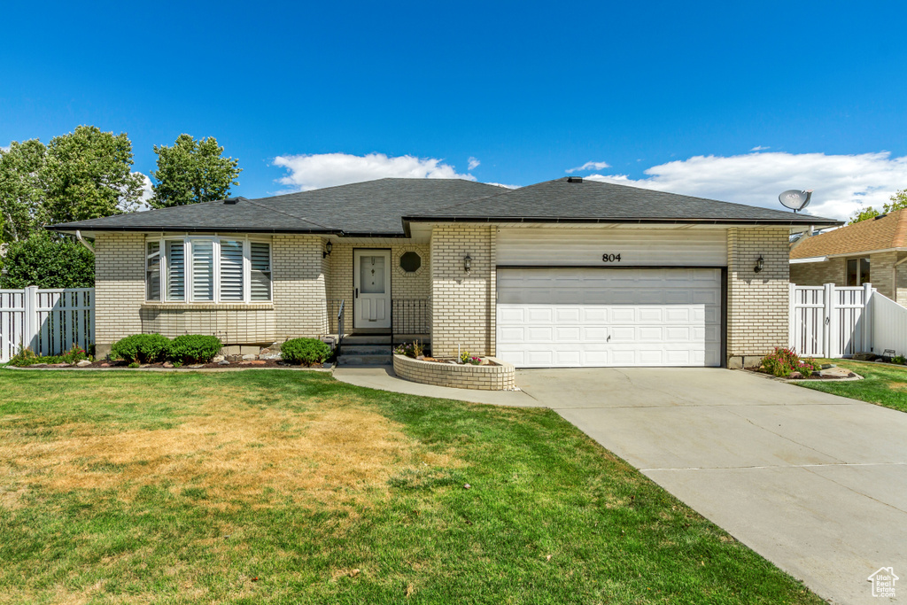 Single story home with a garage and a front yard