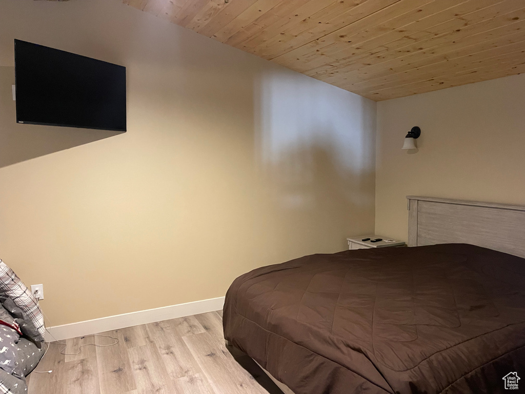 Bedroom with light wood-type flooring and wood ceiling