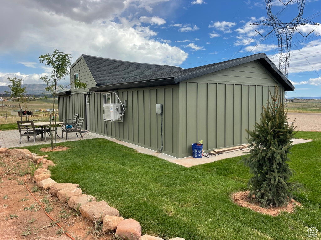 View of property exterior featuring a patio area and a yard