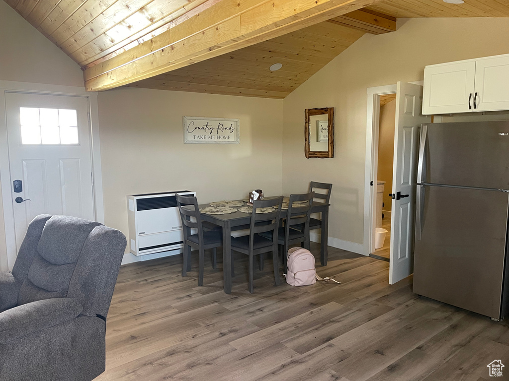 Dining space featuring vaulted ceiling with beams, wooden ceiling, and hardwood / wood-style floors