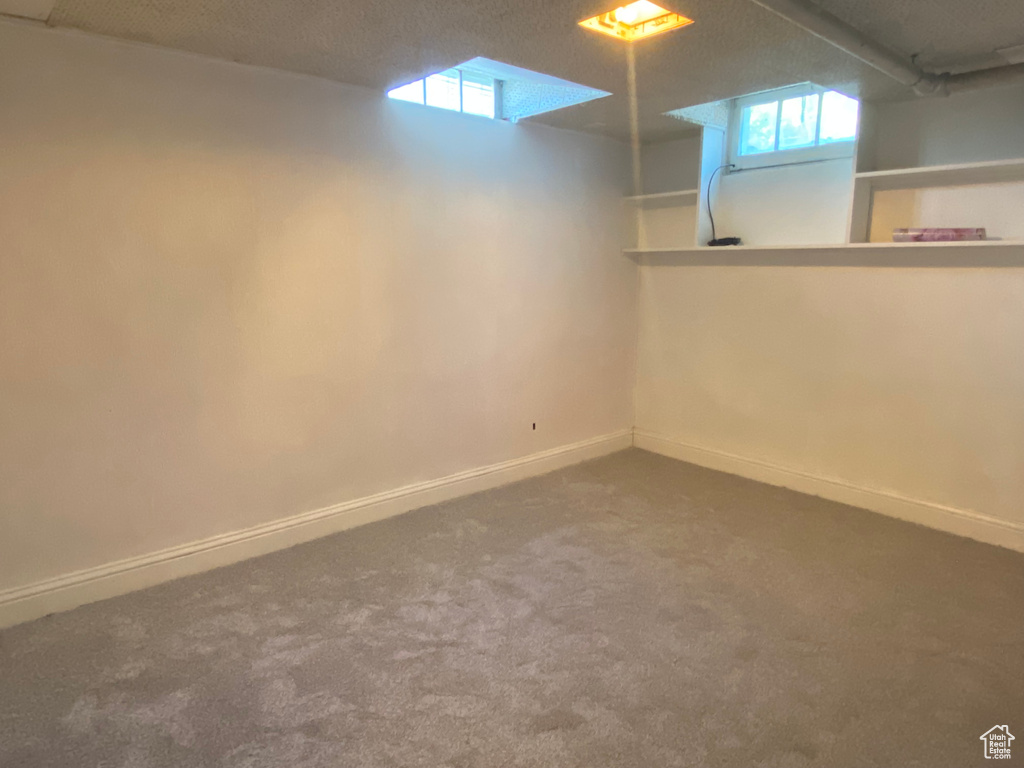 Basement featuring a textured ceiling and carpet floors