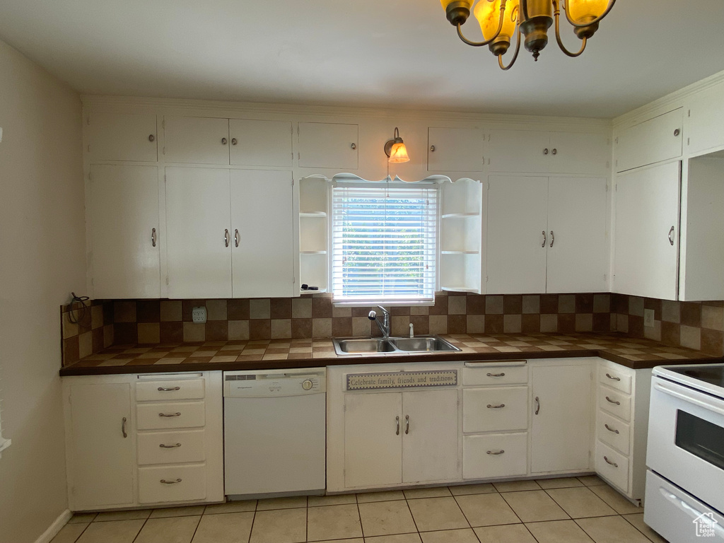 Kitchen featuring sink, white appliances, white cabinetry, and backsplash