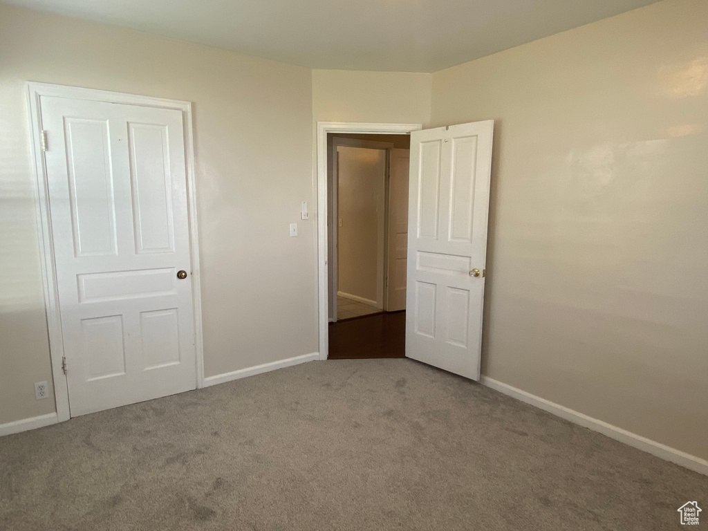 Unfurnished bedroom with a closet and carpet flooring