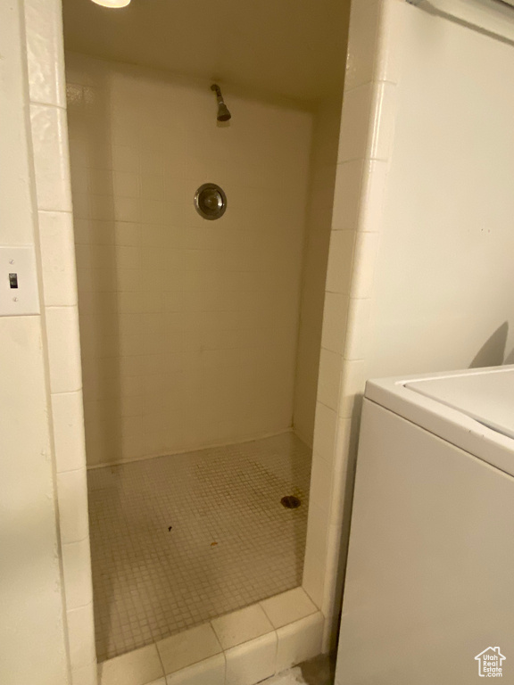 Bathroom with tiled shower and washer / clothes dryer