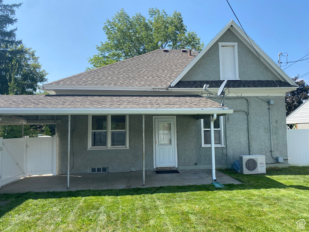 Rear view of property featuring central AC and a lawn