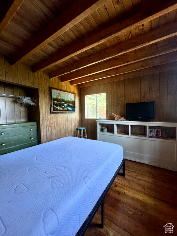 Bedroom with wood walls, wooden ceiling, and hardwood / wood-style flooring