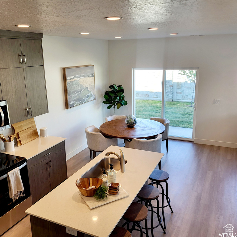 Kitchen featuring a center island, a textured ceiling, light hardwood / wood-style flooring, and appliances with stainless steel finishes