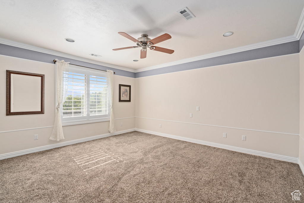 Spare room with carpet floors, ceiling fan, and crown molding