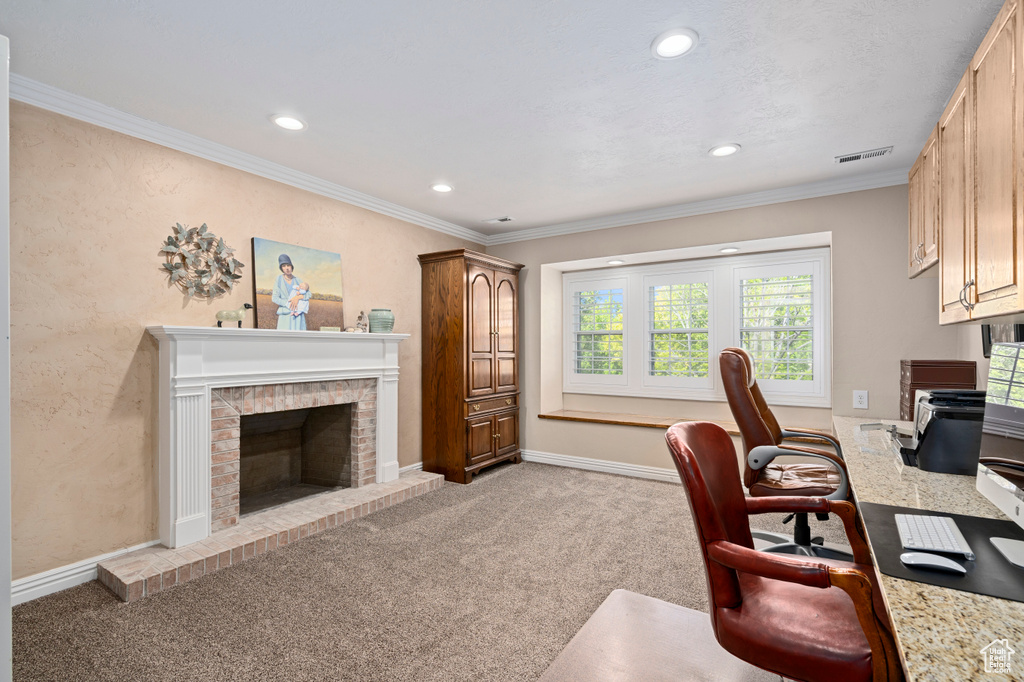 Carpeted home office with crown molding and a brick fireplace