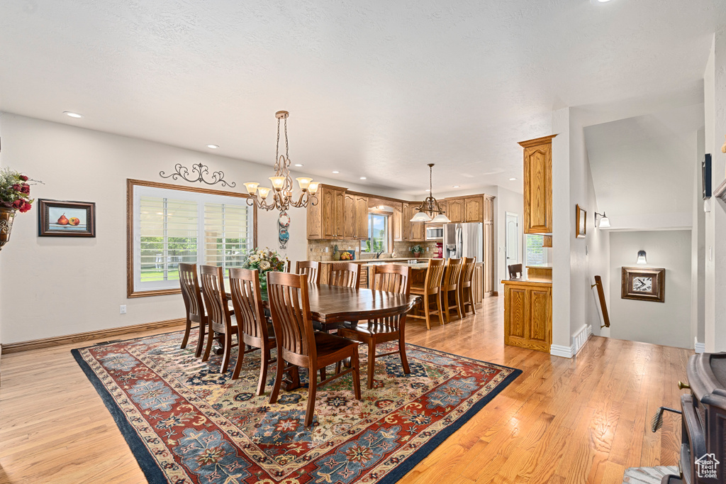 Dining area featuring light wood-type flooring and a notable chandelier