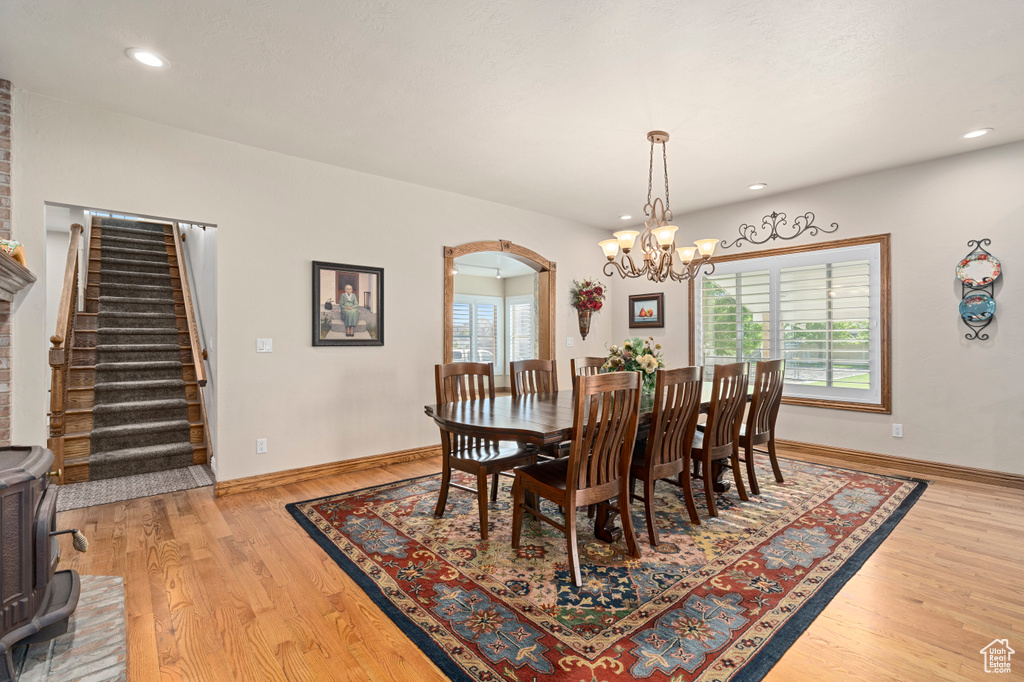 Dining area with light hardwood / wood-style floors and a chandelier