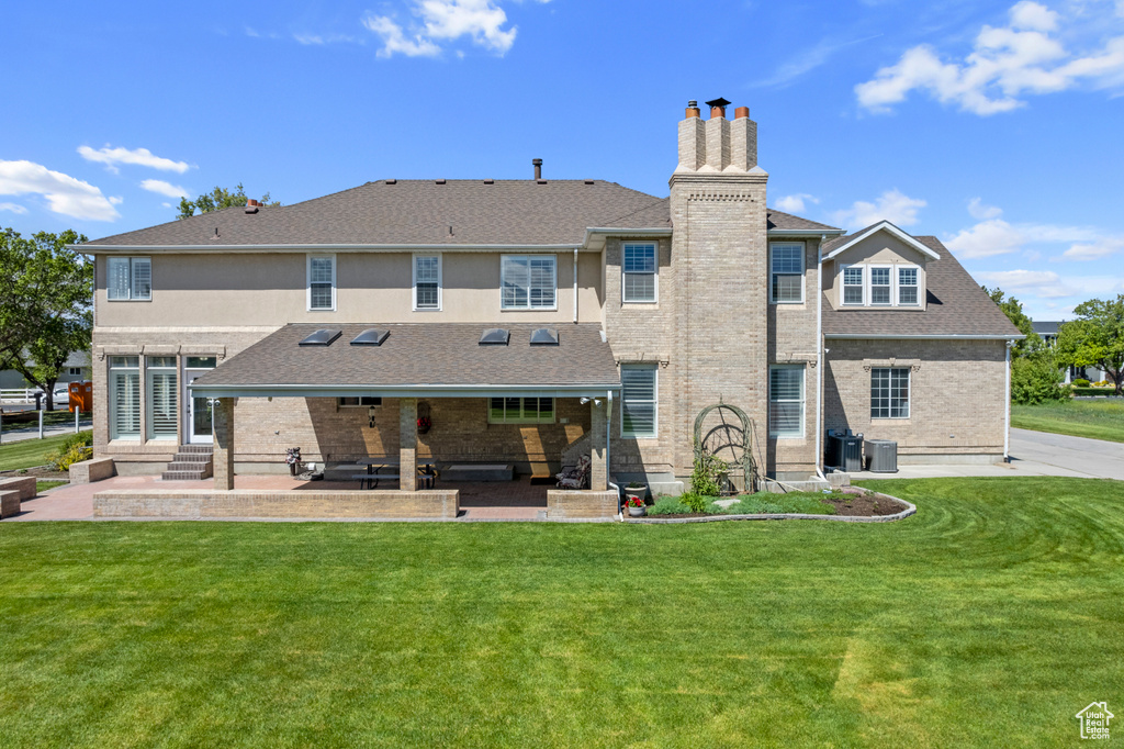 Back of house featuring a patio and a lawn