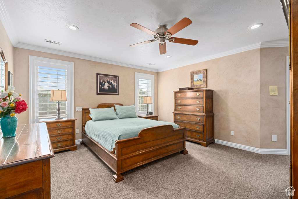 Bedroom featuring ceiling fan, ornamental molding, and light colored carpet