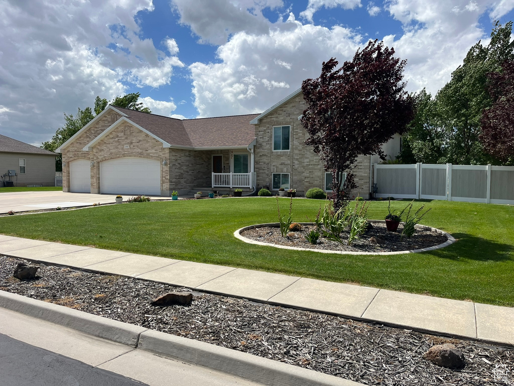 View of front facade featuring a garage and a front lawn