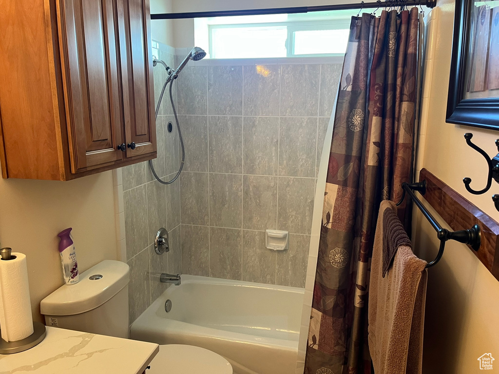 Full bathroom featuring shower / bath combination with curtain, toilet, and vanity