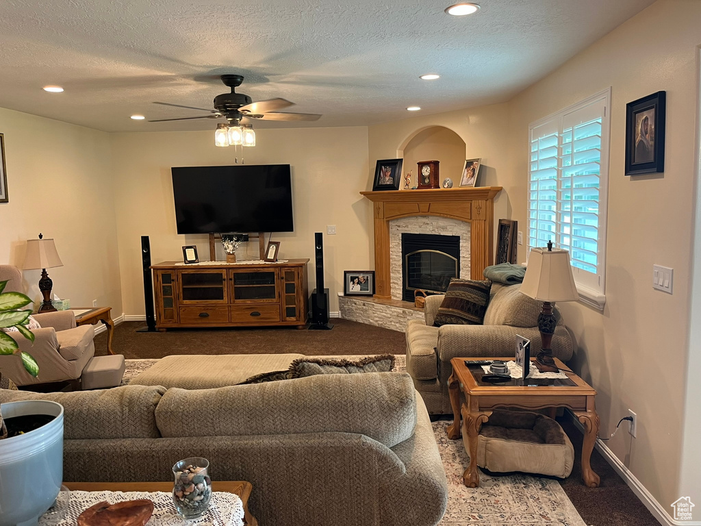 Living room featuring ceiling fan, a textured ceiling, and carpet floors